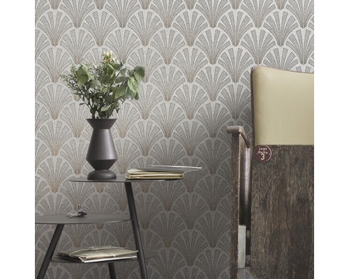 Gros plan d''un mur avec un papier peint à motif en éventail dans une pièce avec une table et une chaise