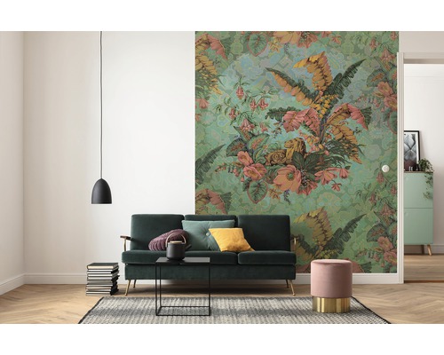 Salon avec canapé vert, papier peint floral et suspension