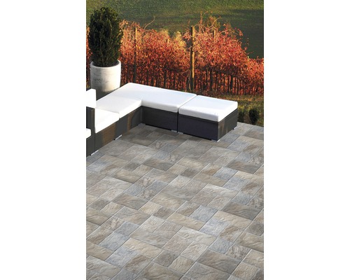 Terrasse mit Steinfliesen und Loungemöbeln im Aussenbereich.