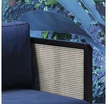 Detailansicht eines blauen Sessels mit Rattanrückenlehne vor floraler Tapete