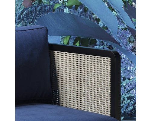 Vue détaillée d''un fauteuil bleu avec dossier en rotin devant un papier peint floral