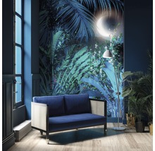 Wohnzimmer mit blauem Sofa, Stehlampe und Wandtapete mit Dschungelmotiv