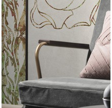 Gros plan d''un fauteuil avec coussin devant un mur à motifs floraux