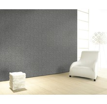 Raumansicht mit grauer Wandtapete, Sessel und Papierstapel