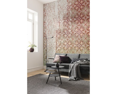 Salon avec papier peint à motifs, canapé, table basse et tapis.