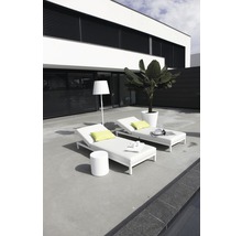 Deux chaises longues de jardin blanches avec une table et un lampadaire sur une terrasse