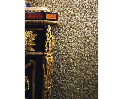 Gros plan d''une armoire antique avec ornements dorés devant un mur structuré