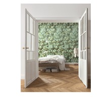 Schlafzimmer mit Doppelbetten, Holzfußboden und einer Wandtapete mit Blattmuster hinter einer offenen Doppeltür