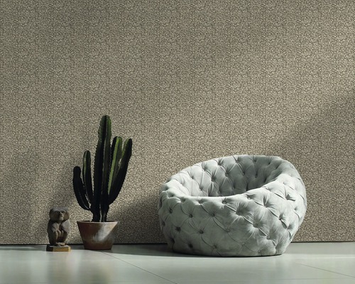 Espace de vie avec papier peint textile, fauteuil, cactus et figurine décorative