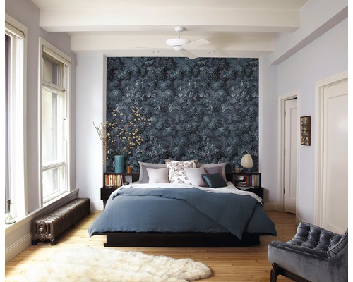 Chambre avec papier peint à motifs floraux, lit et tapis