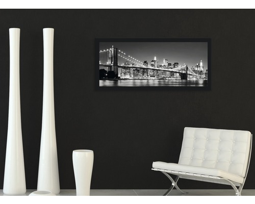 Salon décoratif avec une image encadrée d''un paysage urbain, des vases blanches et un fauteuil