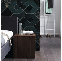 Schlafzimmer mit Bett, Nachttisch und geometrischer Tapete