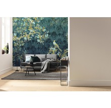 Wohnzimmer mit Sofa vor einer gemusterten Tapete mit Pflanzen- und Vogelmotiven