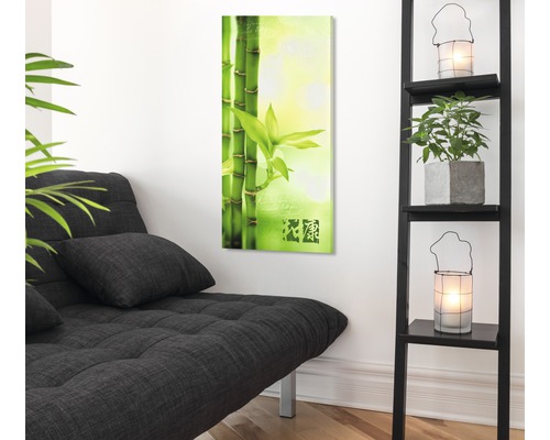 Salon avec tableau de bambous, canapé-lit et étagère