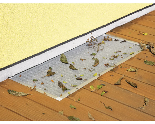 Kellerfensterabdeckung auf einer Terrasse mit Laub