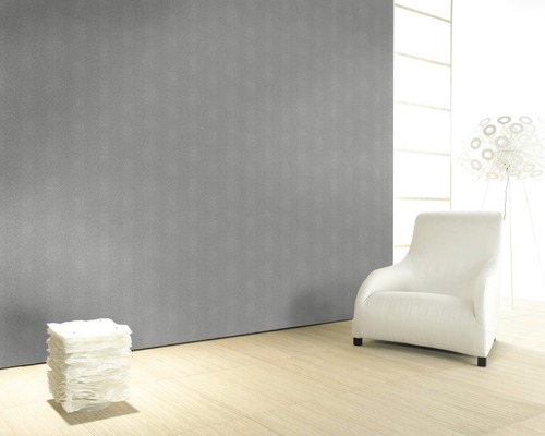 Salon avec mur gris, parquet clair et fauteuil blanc