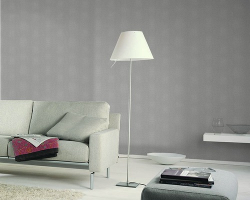 Salon avec canapé, lampadaire et décoration murale pour une ambiance chaleureuse