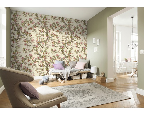 Salon avec papier peint floral à motifs d''oiseaux, fauteuil et tapis pour une ambiance claire et organisée.