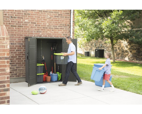Szene mit einem Gartenschrank aus Kunststoff mit zwei Erwachsenen, die Gartengeräte hineinlegen