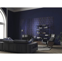 Wohnzimmer mit Sofa, Sessel, Regal und geometrischer Tapete