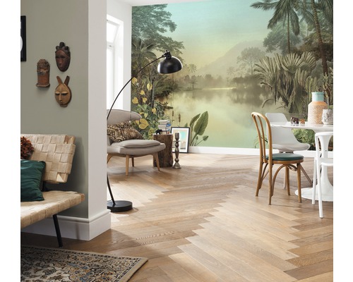 Salon avec papier peint photo tropical, parquet à chevrons, sièges et lampadaire.