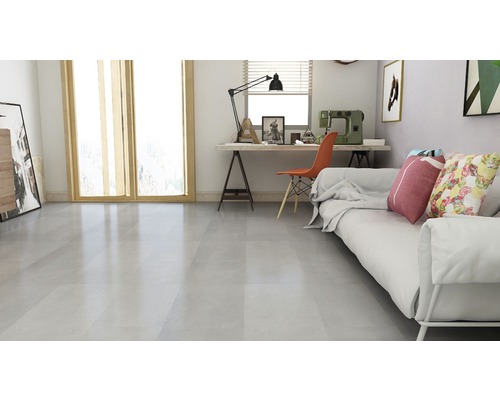 Heller Wohnraum mit Sofa, Schreibtisch und Bodenfliesen.