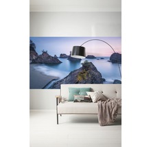 Wandbild mit Strandlandschaft über einem Sofa mit Stehlampe