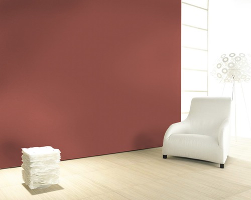 Pièce lumineuse avec mur coloré, fauteuil et lampe