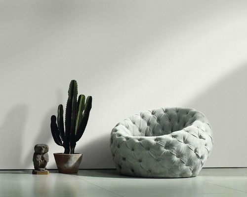 Scène de salon avec un fauteuil rembourré, un cactus et une figurine décorative de hibou