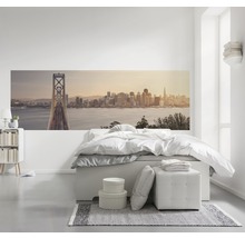 Helles Schlafzimmer mit Wandbild einer Stadtlandschaft, Bett und Nachttisch