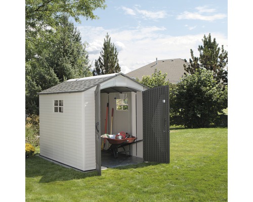 Scène de jardin avec remise, brouette et outils de jardin