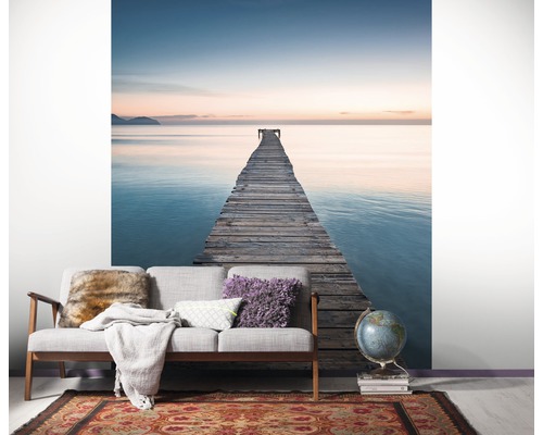 Wohnzimmer mit Fototapete, die einen Holzsteg ins Meer zeigt