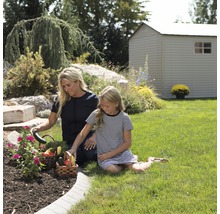 Mère et fille récoltent des légumes dans le jardin avec une remise de jardin