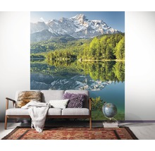 Wandbild mit Bergsee-Motiv in einem Wohnraum mit Sofa und Teppich