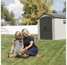 Scène de jardin avec abri de jardin, mère et fille regardant des légumes dans un panier