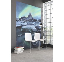 Raum mit Fototapete mit Bergmotiv, zwei weißen Stühlen und Stehleuchte