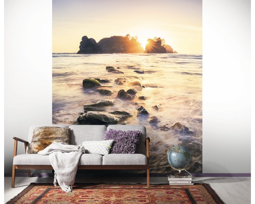 Ambiance de pièce avec papier peint photo d''une plage avec des rochers dans la mer au lever du soleil