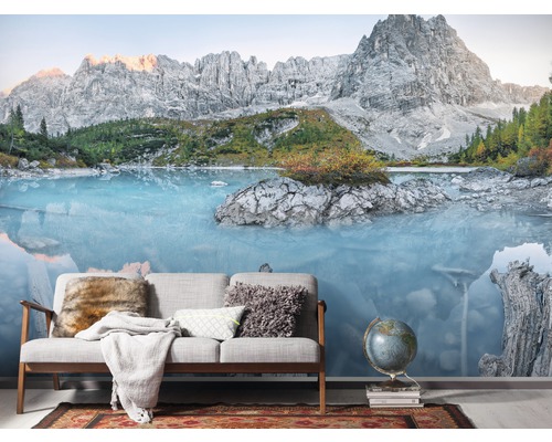 Papier peint photo avec motif de lac de montagne derrière un canapé et un globe