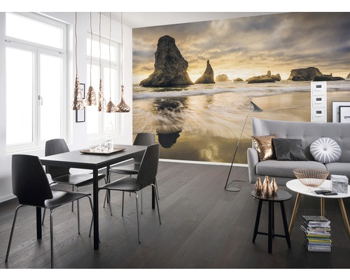 Wohnraum mit Fototapete einer Küstenlandschaft, Esstisch und Sofa.