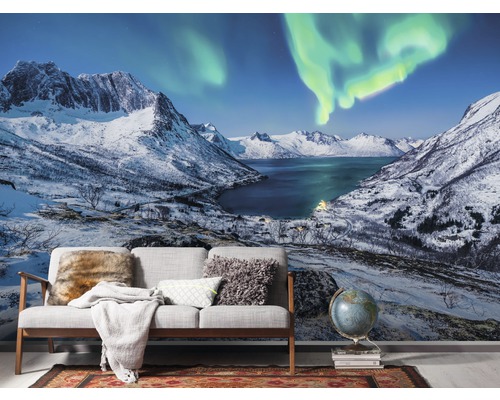 Papier peint avec paysage de montagne, lac et aurores boréales derrière un canapé