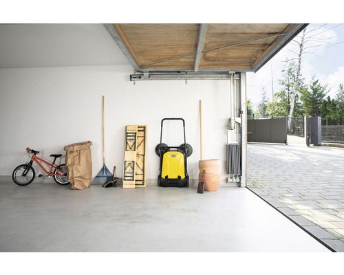 Garage avec balayeuse, râteau à gazon, vélo d''enfant et pots de fleurs