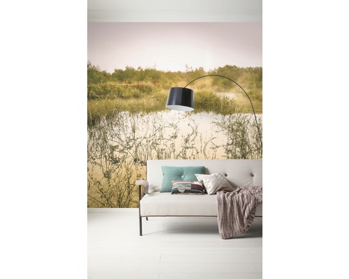 Salon avec canapé, lampe et papier peint photo avec motif de paysage