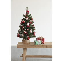 Sapin de Noël décoré avec des cadeaux sur une table en bois.