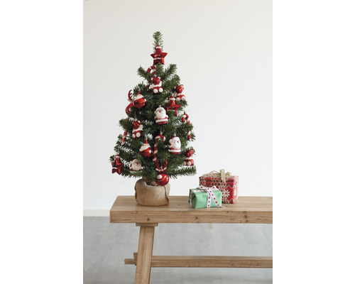 Sapin de Noël décoré avec des cadeaux sur une table en bois.