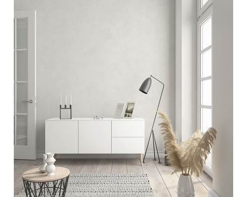 Helles Wohnzimmer mit weißem Sideboard, Stehlampe und Dekorationen.