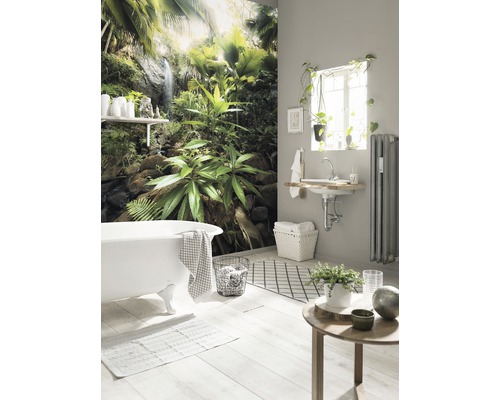 Salle de bain avec baignoire, lavabo, radiateur, décoration et papier peint photo avec motif de jungle pour une ambiance relaxante