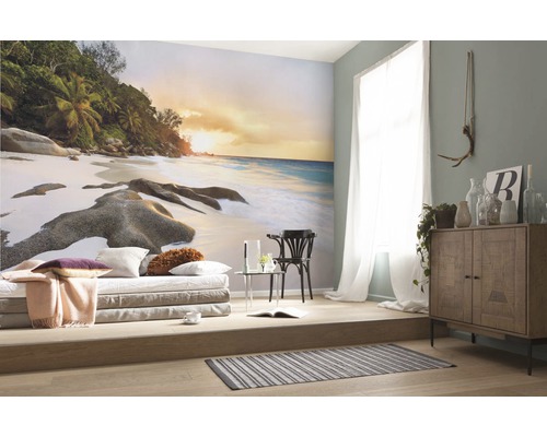 Wohnraum mit Fototapete Strandmotiv, Sitzgelegenheit und Holzkommode