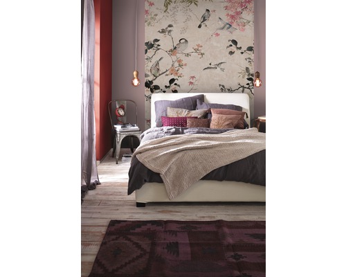 Chambre à coucher avec papier peint floral, lit et tapis