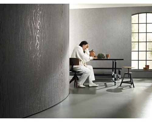 Pièce lumineuse avec papier peint design gris et personne assise à table