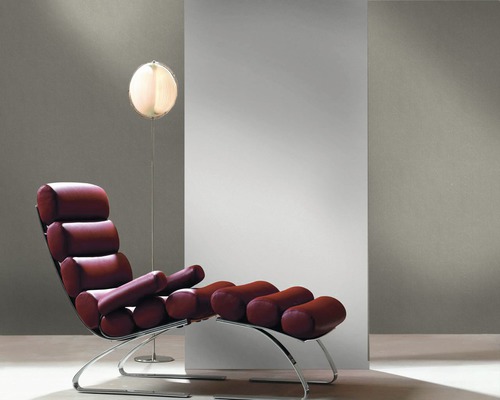 Chaise longue avec coussins cylindriques et lampadaire dans un intérieur